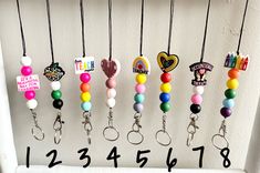 a number of key chains hanging on a wall with the numbers in front of them