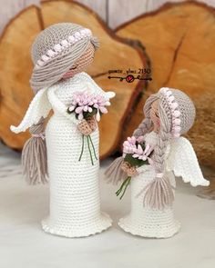 two crocheted angel figurines with flowers in their hands, one holding the other's hand