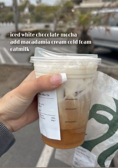 a person holding up a plastic cup with liquid in it and the words iced white chocolate mecha add maximum cream cold foam