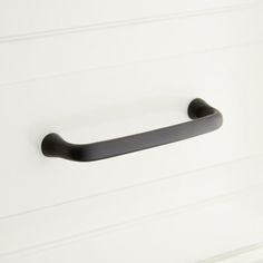 a black handle on a white cabinet door