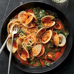 a bowl filled with pasta and clams on top of a table