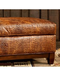 a brown leather ottoman sitting on top of a rug