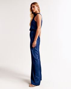 Elevate your wardrobe with the Abercrombie & Fitch Women's High-Neck Draped Jumpsuit, a perfect blend of elegance and comfort. This sophisticated piece is designed in a rich navy hue and crafted from silky satin fabric that gracefully drapes along the bodice.

- Size: XL
- Color: Navy
- Material: Upper Body Lining: Polyester
- Gender: Female
- Features: High-neck detail, back keyhole closure, elasticated waistband, wide-leg pants

Ideal for both daytime sophistication and evening chic, this jump Fitted Satin Jumpsuits And Rompers For Work, Chic Fitted Satin Jumpsuits And Rompers, Elegant High Neck Jumpsuit For Night Out, Fitted Satin Jumpsuits And Rompers For Date Night, Chic Sleeveless Satin Jumpsuit, Sleeveless Silk Jumpsuits And Rompers For Party, Chic Silk Jumpsuits And Rompers For Party, Chic Silk Jumpsuits And Rompers, Sleeveless Silk Fitted Jumpsuit