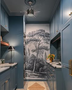 a bathroom with blue cabinets and a mural on the wall