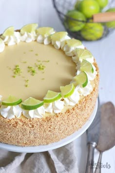 a cake with limes and whipped cream on top