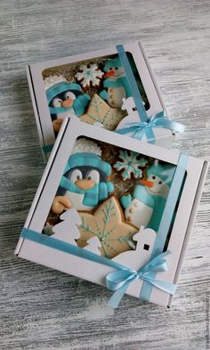 two decorated cookies in a box on a table