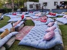 many mattresses are laid out on the grass