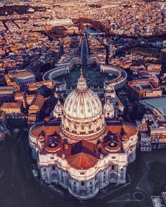 an aerial view of a city with many buildings and large dome shaped building in the center