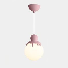 a pink and white light hanging from a ceiling fixture with an object in the background