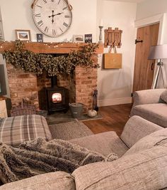 a living room filled with furniture and a clock on the wall over a fire place