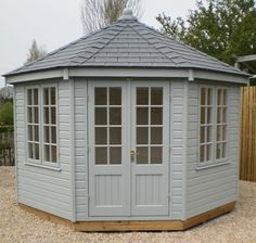 a small gray wooden gazebo sitting on top of gravel