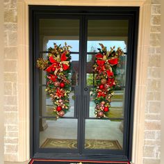 two christmas wreaths on the front door of a building with red and gold decorations