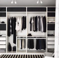 an open closet with clothes hanging on it