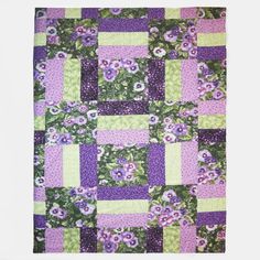 a purple and green quilt with flowers on it