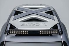 the front end of a silver car with lights on it's headlamps