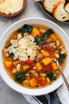 a white bowl filled with soup next to bread