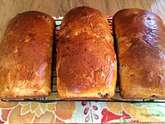 four loafs of bread sitting on top of a cooling rack