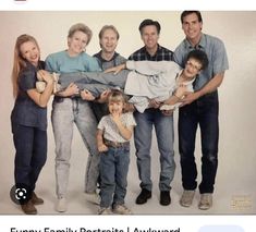 a group of people posing for a photo with one holding a baby and the other holding an infant