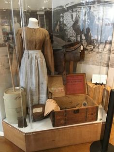 an old fashion display case filled with antique items