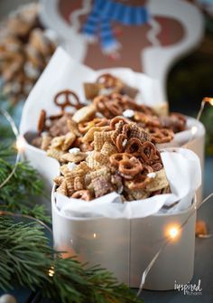 two white boxes filled with christmas cheerios and pretzels sitting on a table