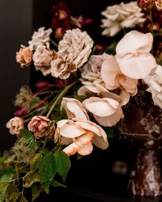 a vase filled with lots of flowers on top of a table