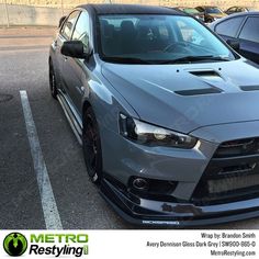 a grey car parked in a parking lot next to other cars