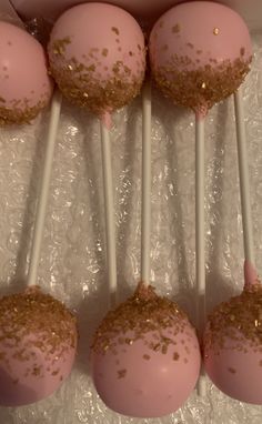 pink cake pops with gold sprinkles in a box