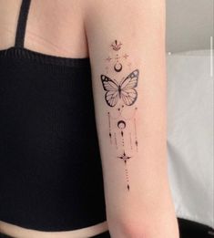 a woman's arm with a butterfly and stars tattoo on the left side of her arm