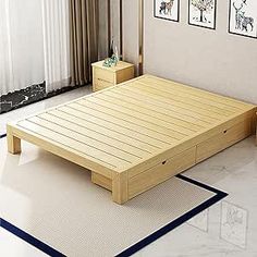 a bed sitting on top of a white floor next to a wooden table with drawers