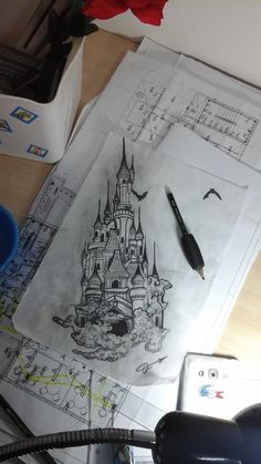 a drawing of a castle on top of some paper with a pen next to it