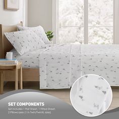 the bed is made with white linens and has animals printed on it, along with two pillows