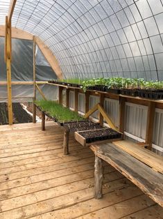 a wooden bench sitting on top of a hard wood floor next to a green house