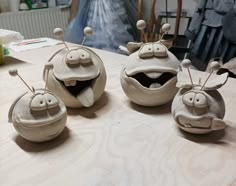 three clay sculptures sitting on top of a table