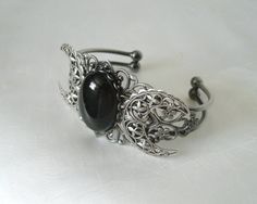 This beautiful silver plated cuff bracelet has a silver plated triple moon design and a large obsidian setting. Adjustable. Adjustable Mystical Silver Bracelet, Adjustable Silver Mystical Bracelet, Gothic Bangle Bracelet For Gift, Adjustable Gothic Crescent Jewelry, Gothic Silver Bracelet, Handmade Silver Gothic Bracelet, Handmade Silver Gothic Bracelets, Handmade Gothic Silver Bracelets, Silver Gothic Bangle