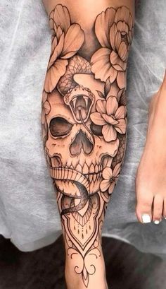 a woman's leg with flowers and a skull on it