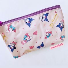 a small pink and purple bag with cartoon characters on it, sitting on a white surface