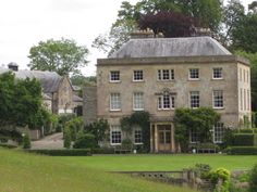 a large stone house with lots of windows and ivy growing on it's roof