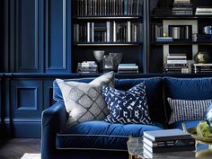 a living room with bookshelves and blue couches in the centerpieces