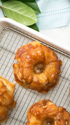 four doughnuts on a cooling rack with leaves