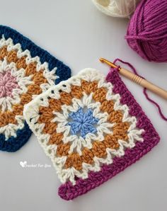 two crocheted grannys are next to a ball of yarn