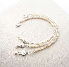 Bridesmaid Bracelet, Pearl Bracelet, Initial Bracelet, Personalized Jewelry, Bridesmaid Gift There are oodles of pearls on these bracelets. They make a lovely gift for your bridesmaids. One that they can wear well after your wedding day! + Small Freshwater Pearls (size of pearls are approx. 3mm) Sterling Silver Initial & Lobster Clasp. + Initial: Pick upon checkout. + Bracelet Length: Pick upon checkout. + Your jewelry will come in a jewelry box, tied with a ribbon, ready for gift giving. Th Elegant Adjustable Bridesmaid Bracelets, Elegant Adjustable Name Bracelet With Round Beads, White Pearl Drop Bracelets For Bridesmaids, White Pearl Drop Bracelet For Bridesmaids, Pearl Bracelets For Bridesmaid Gift, Personalized Round Bead Pearl Bracelet For Wedding, Wedding Bracelets With Pearl Charm, White Beaded Bracelets With Pearl Charm For Bridesmaids, Personalized Adjustable Pearl Bracelet