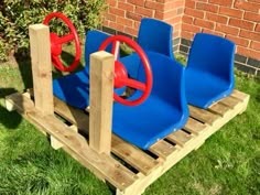 two blue chairs with red wheels are on a wooden pallet