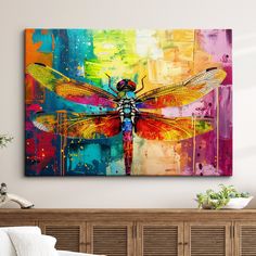 a colorful dragonfly painting on a wall above a bed