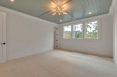 an empty room with white walls and carpet