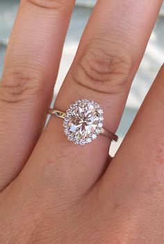 a woman's hand with a diamond ring on top of her finger and an engagement band