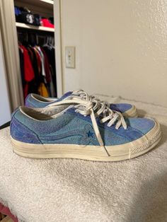 a pair of blue tennis shoes sitting on top of a white counter next to a closet