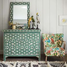 a green and white dresser sitting next to a chair with a mirror on top of it