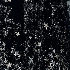 black and white photograph of stars in the night sky with snow flakes on it