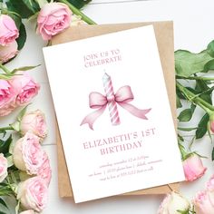 a birthday card with a pink bow on it and flowers around the card reads, join us to celebrate elizabeth's 1st birthday