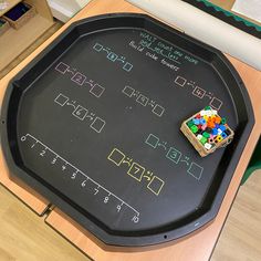 a child's blackboard with numbers and legos on it sitting on a table